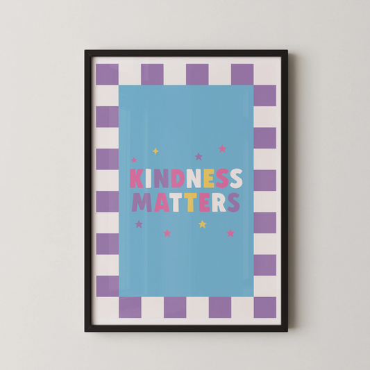 A Pop Art style poster with the bold multicolored typographic phrase KINDNESS MATTERS on a sky-blue panel, framed by a lavender checkerboard border.